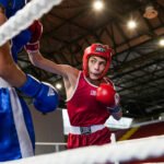 Mladi borac baca udarac prema svome protivniku u konope ringa