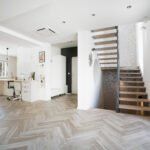 Prazna dnevna soba s modernim dizajnom i drvenim stepenicama koje vode na gornji kat