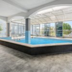 unutarnji bazena s staklenim zidovima koji okružuju prostoriju, omogućujući pogled na vanjski okoliš