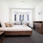 Fotografija spavaće sobe s modernim namještajem, udobnim krevetom i umirujućom atmosferom